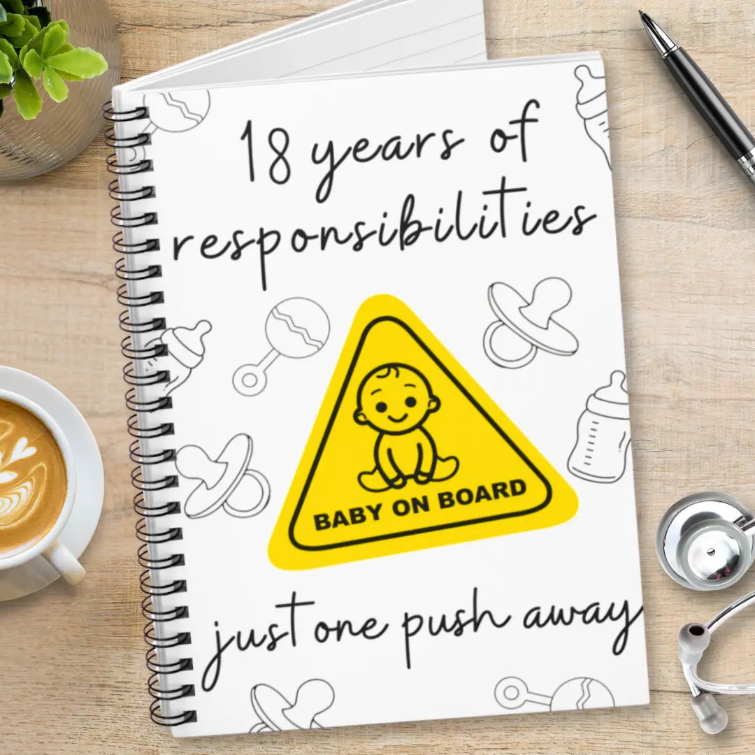 Labor and delivery notebook with '18 years of responsibilities' and 'Baby on Board' logo on a wooden surface.