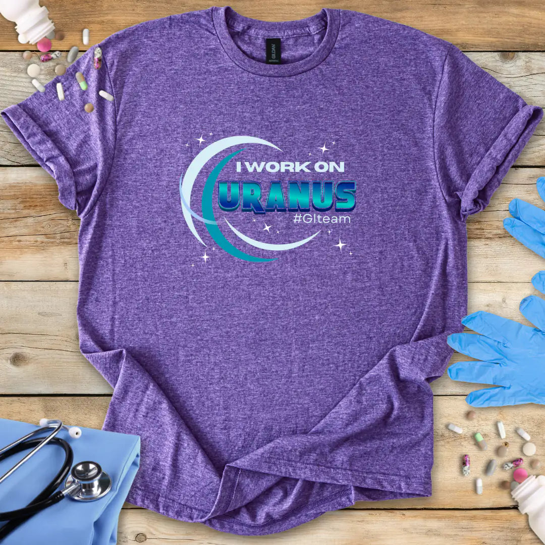 Heather purple med-t-shirt with 'I Work on Uranus' graphic on a wooden surface with medical supplies.