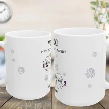 Two white mugs with cartoon designs and text on a wooden surface.