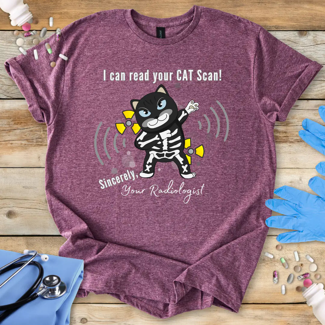 Heather Maroon t-shirt with cartoon cat in an x-ray and 'I can read your cat scan your radiologist' text on a wooden surface with medical-themed props.