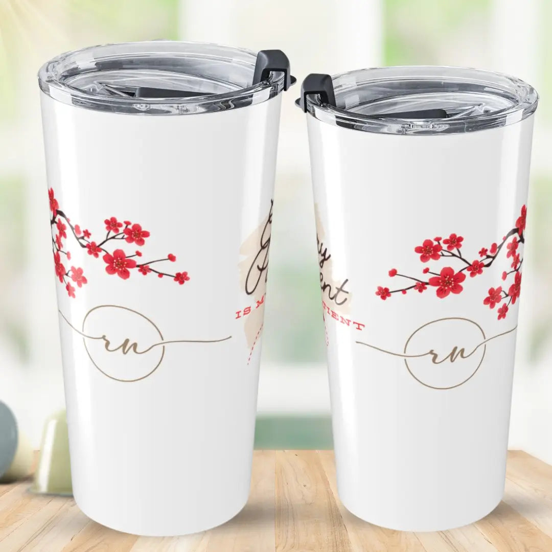 Two white tumblers with cherry blossom design and 'RN' text on a wooden surface.