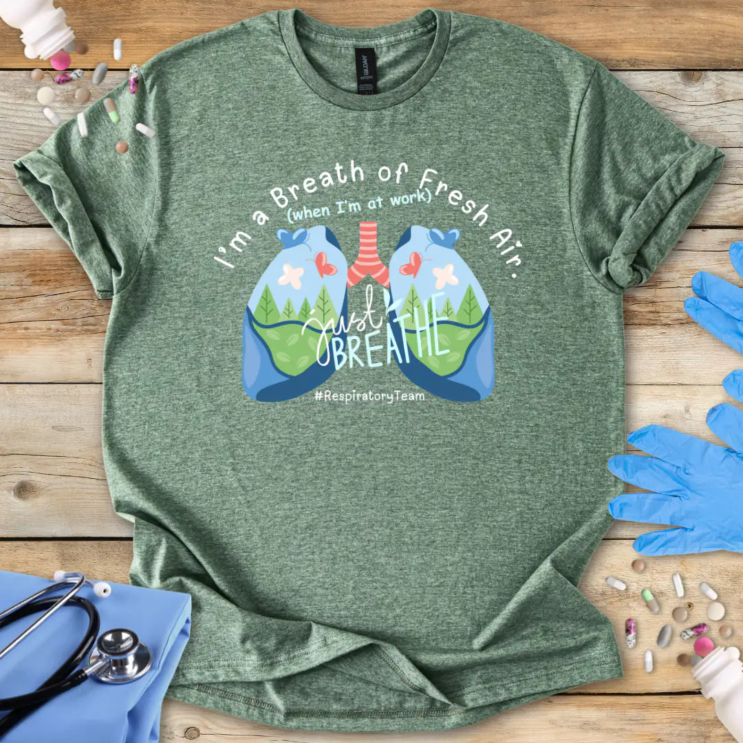 Military Green t-shirt with lungs graphic and 'respiratory team' text on a wooden surface with medical accessories.