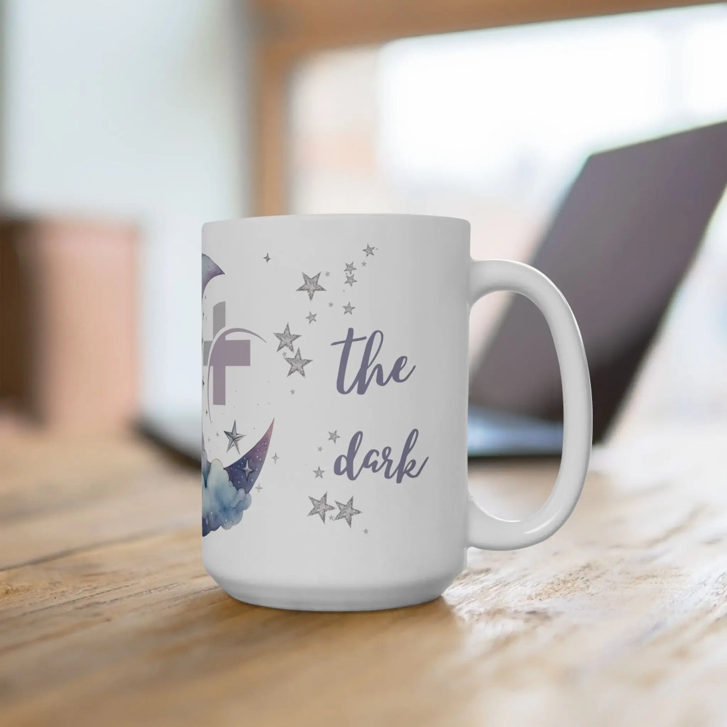White mug with 'The Dark' text and stars on a wooden surface