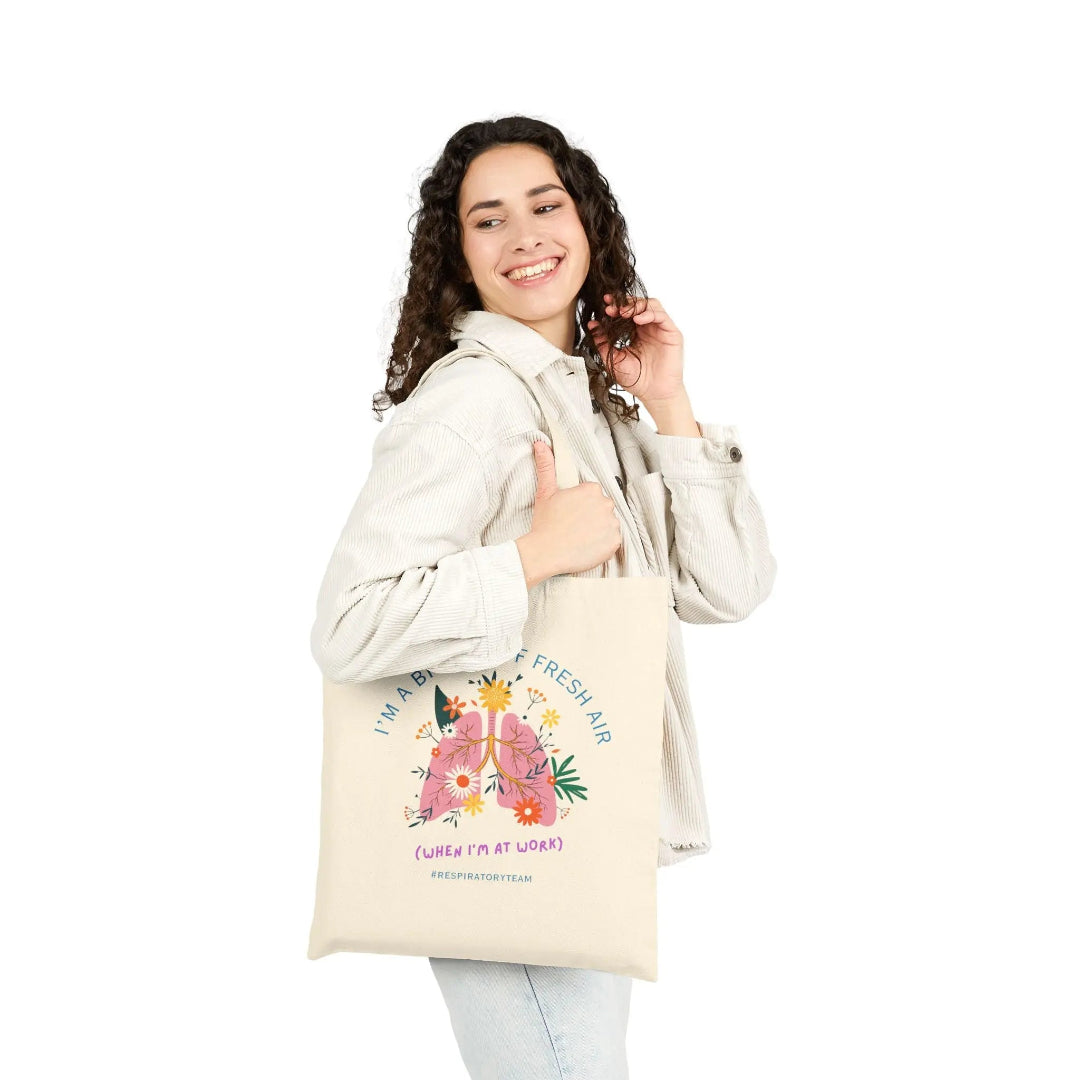 Woman holding a tote bag with floral design and text on a white background