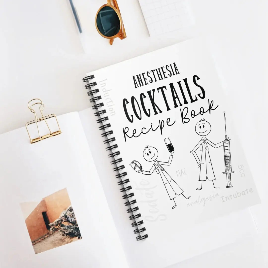 Notebook titled 'Anesthesia Cocktails Recipe Book' with stick figure illustrations on a white surface.