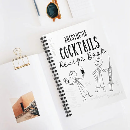 Notebook titled 'Anesthesia Cocktails Recipe Book' with stick figure illustrations on a white surface.