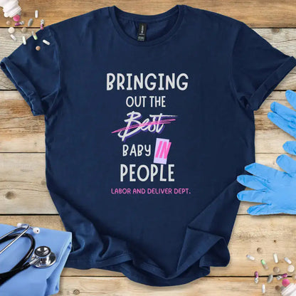 Navy blue t-shirt with humorous text on a wooden surface with medical-themed items.