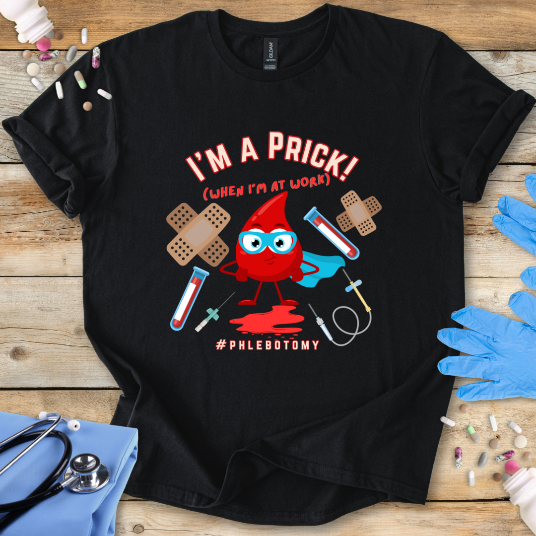Black t-shirt with a graphic design featuring a blood drop character and text 'I'm A Prick Phlebotomy' on a wooden surface with medical accessories.