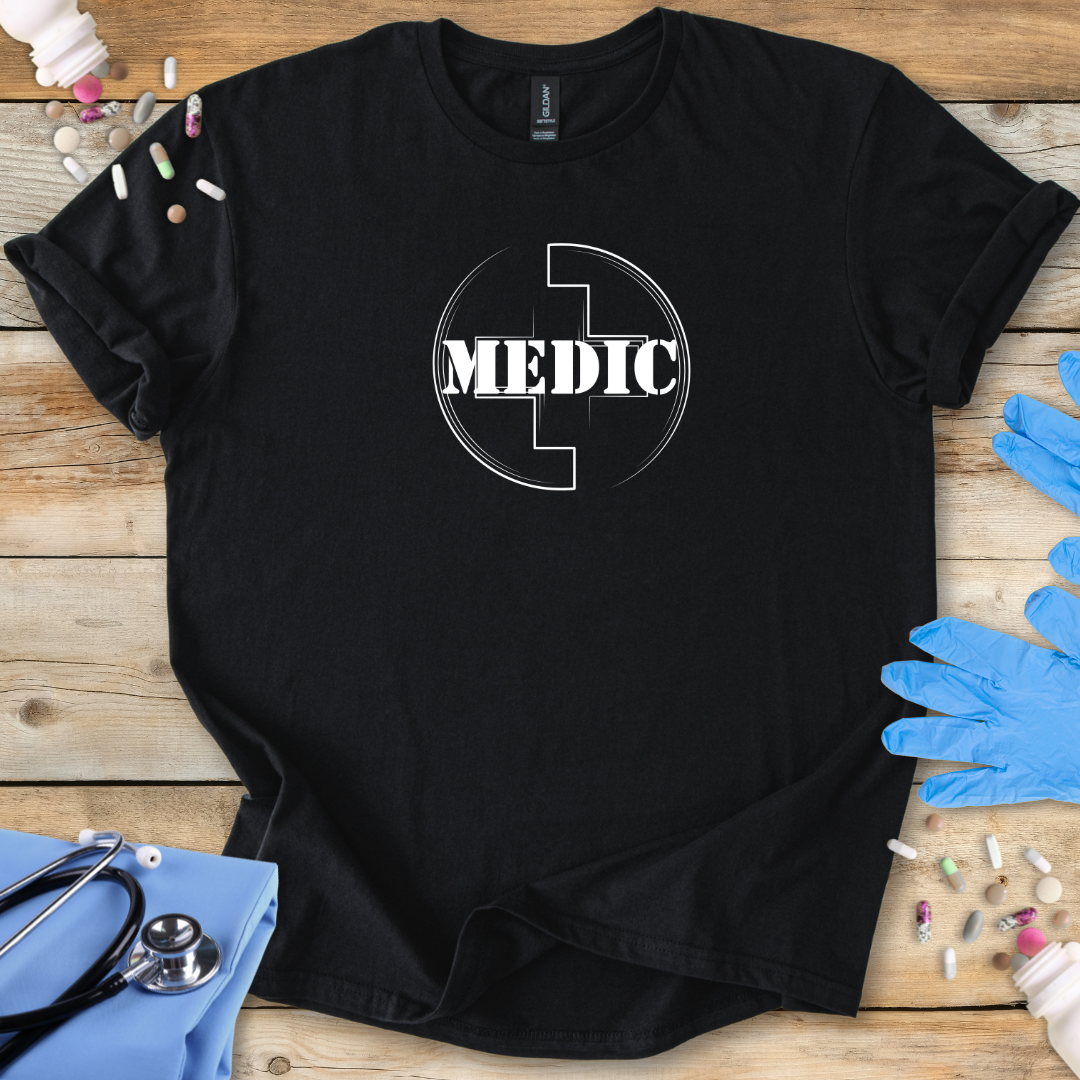 Black t-shirt with 'MEDIC' logo on a wooden surface with medical supplies.