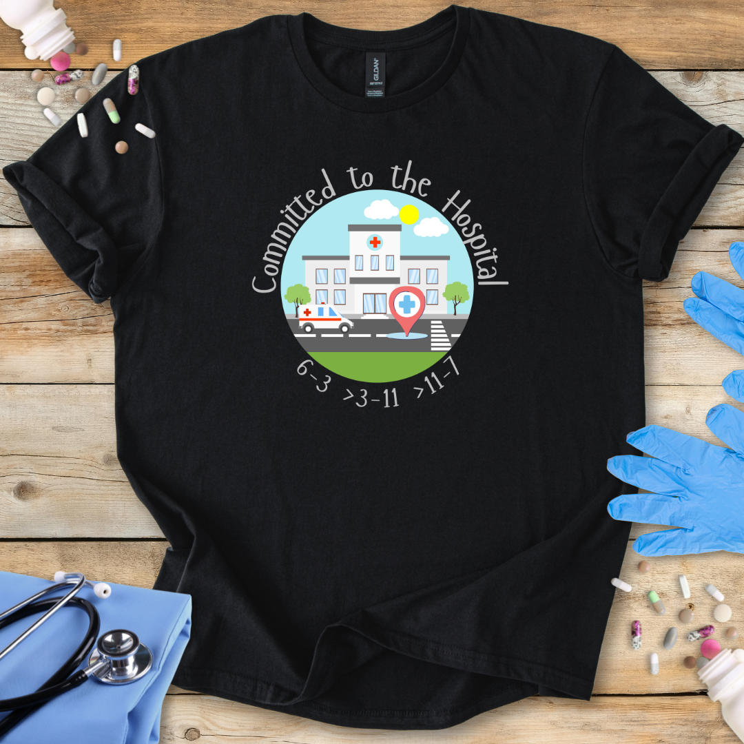 Black t-shirt with a hospital-themed graphic and 'Committed To The Hospital' on a wooden surface with medical supplies.