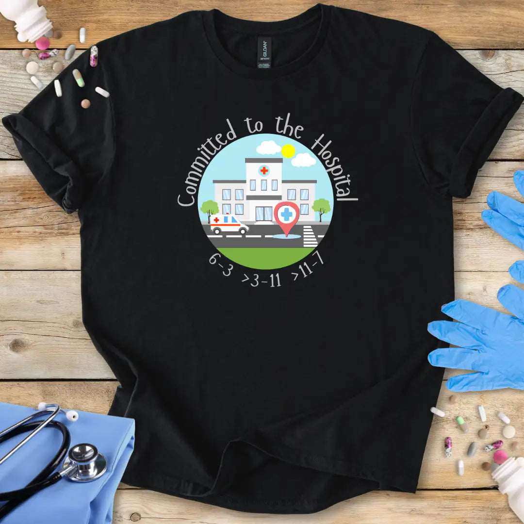 Black t-shirt with a hospital-themed graphic and 'Committed To The Hospital' on a wooden surface with medical supplies.