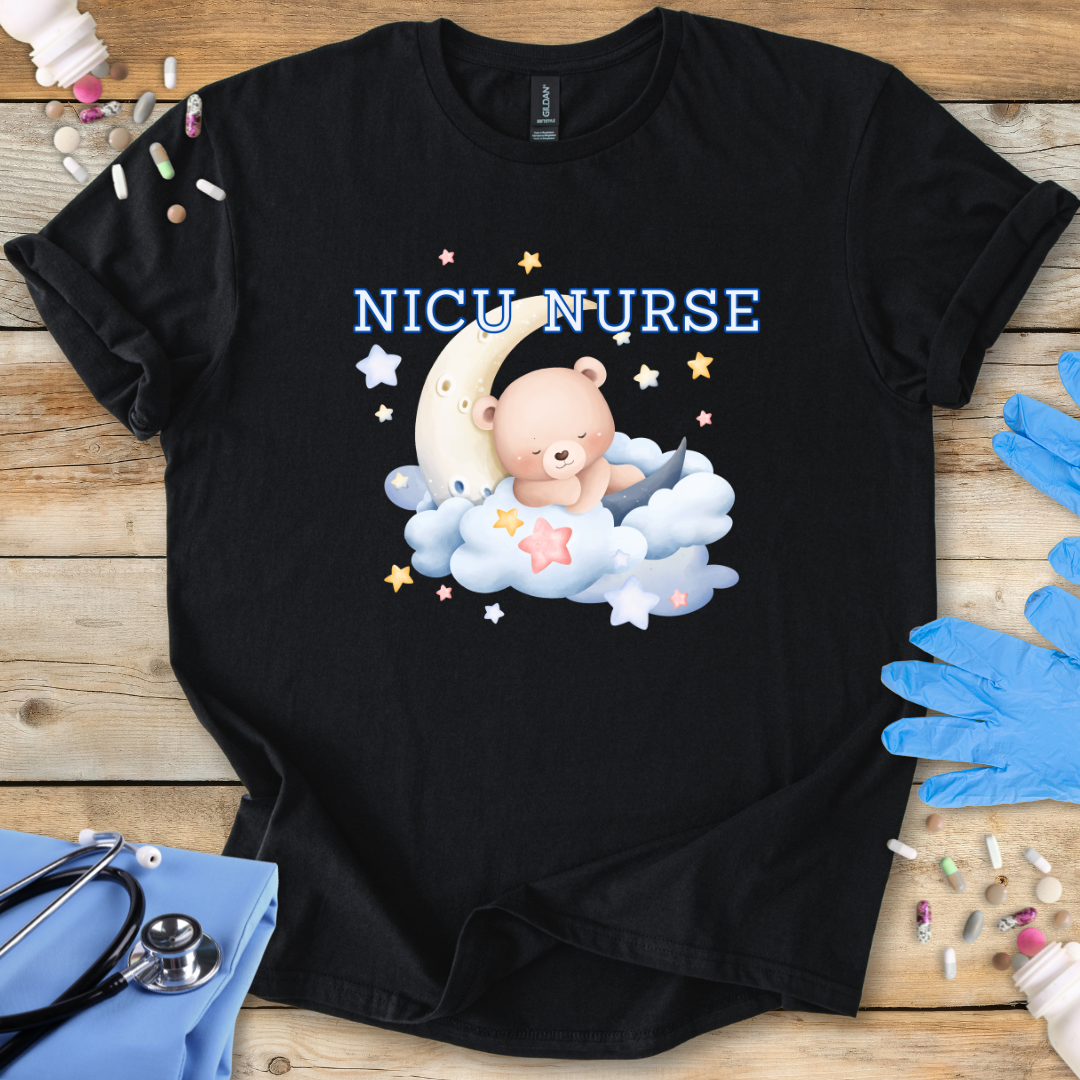 Black t-shirt with NICU Nurse text  featuring a teddy bear and baby on a wooden surface with medical supplies.