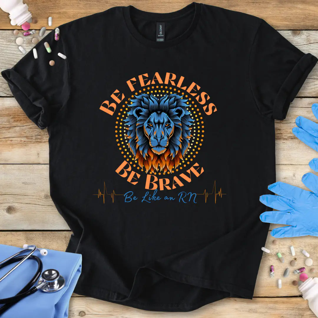 Black t-shirt with a lion graphic and text 'Be Fearless Be Brave Be Like an RN' on a wooden surface with medical supplies.