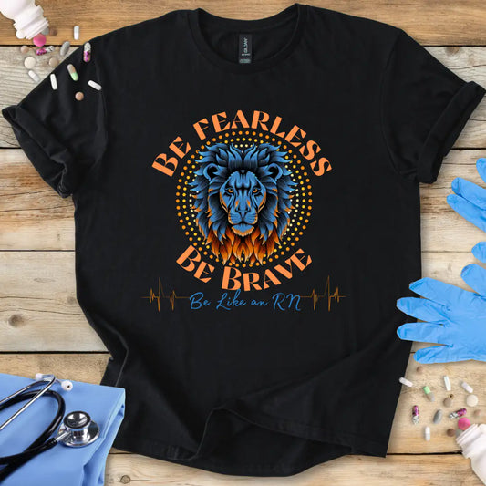 Black t-shirt with a lion graphic and text 'Be Fearless Be Brave Be Like an RN' on a wooden surface with medical supplies.