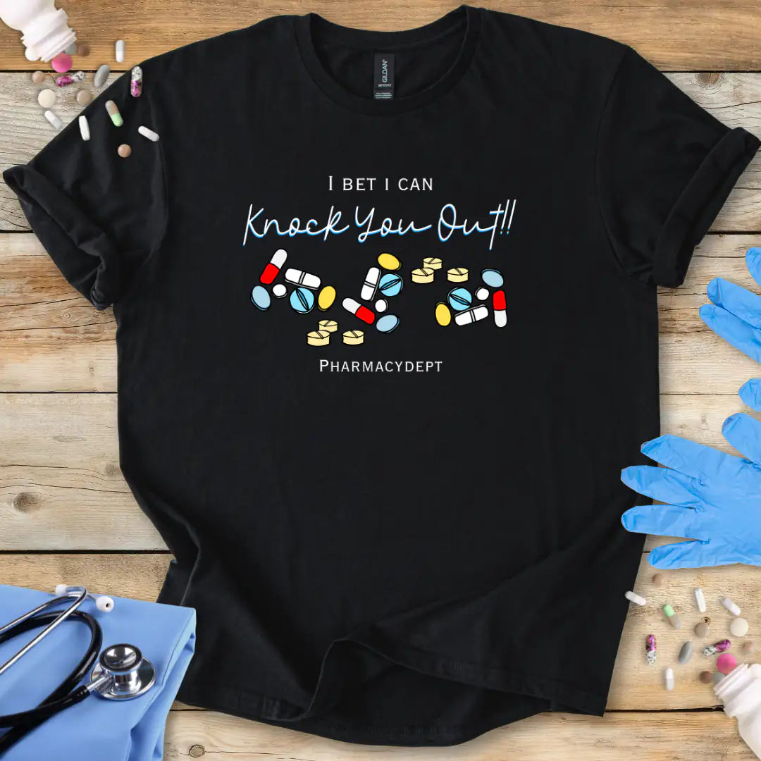 Black t-shirt with pharmacy-themed design with the text 'I bet i can knock you out' on a wooden surface with medical accessories.