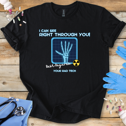 Black med t-shirt with medical radiology themed graphic and 'I can see right through you' text on a wooden surface with medical gloves.