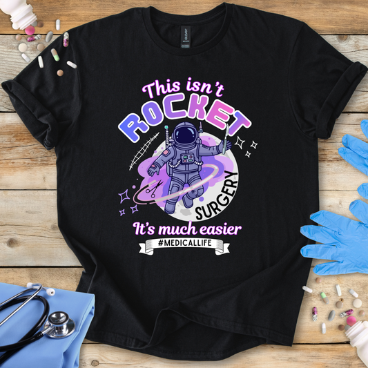 Black t-shirt with an astronaut graphic and text on a wooden surface with medical supplies.