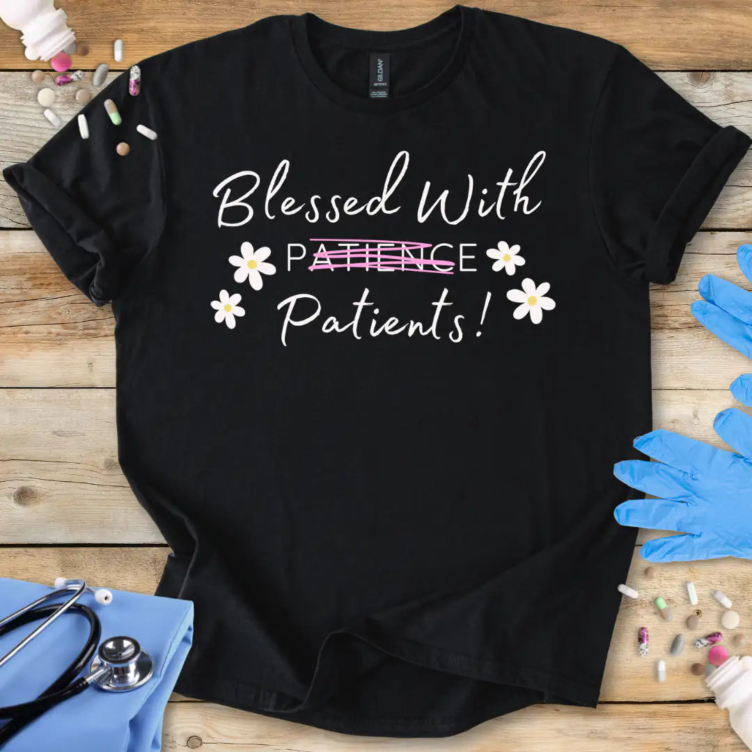 Black t-shirt with 'Blessed With Patients' text on a wooden surface with medical accessories and medications.