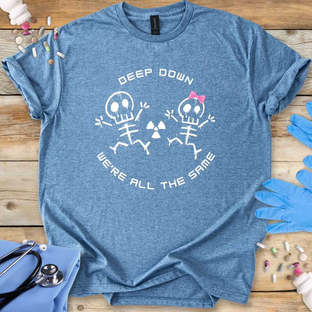 Blue t-shirt with radiology skeleton design and 'Deep down we are all the same' text on a wooden surface with medical supplies.