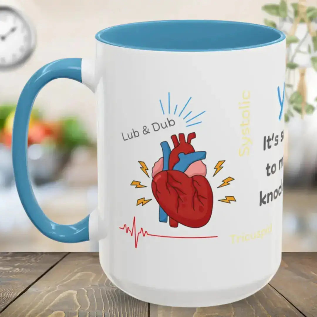 White mug with blue interior and handle, featuring a heart illustration and text on a wooden surface.