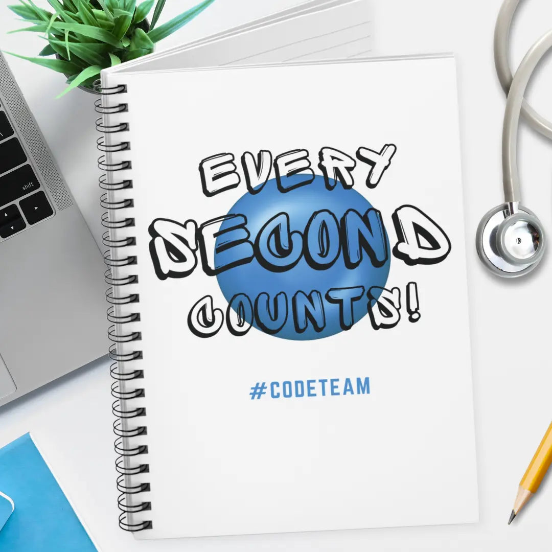 Notebook with 'Every Second Counts! #CODETeam' text on a desk with a laptop and stethoscope.