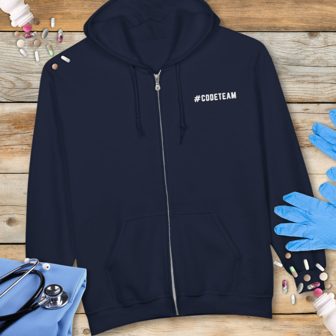 Navy blue hoodie with '#CODETEAM' text on a wooden surface with medical supplies.