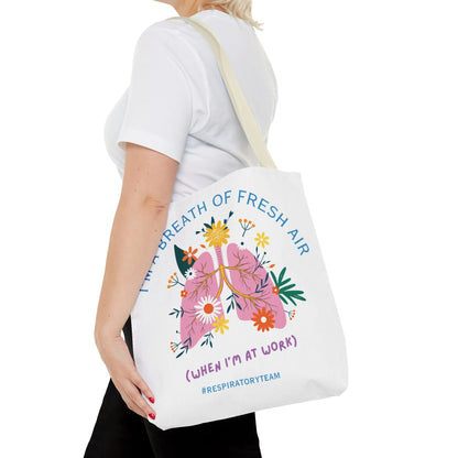 Tote bag with lungs design and text held by a person on a white background