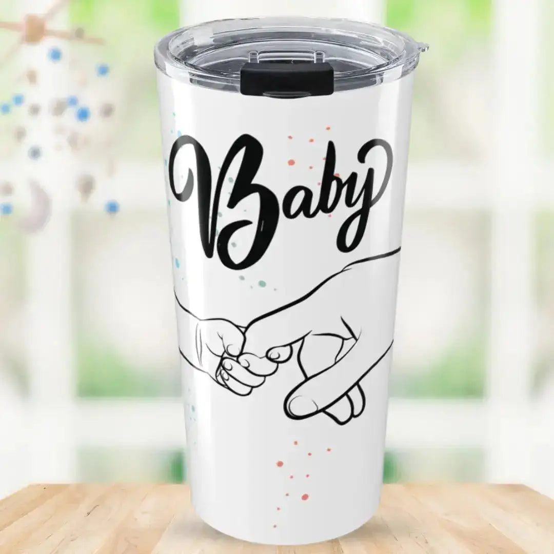 White tumbler with 'Baby' and hand illustration on a blurred natural background