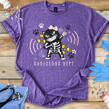 Purple t-shirt with a cartoon skeleton cat design and 'Radiology Dept.' text, placed on a wooden surface with medical accessories.