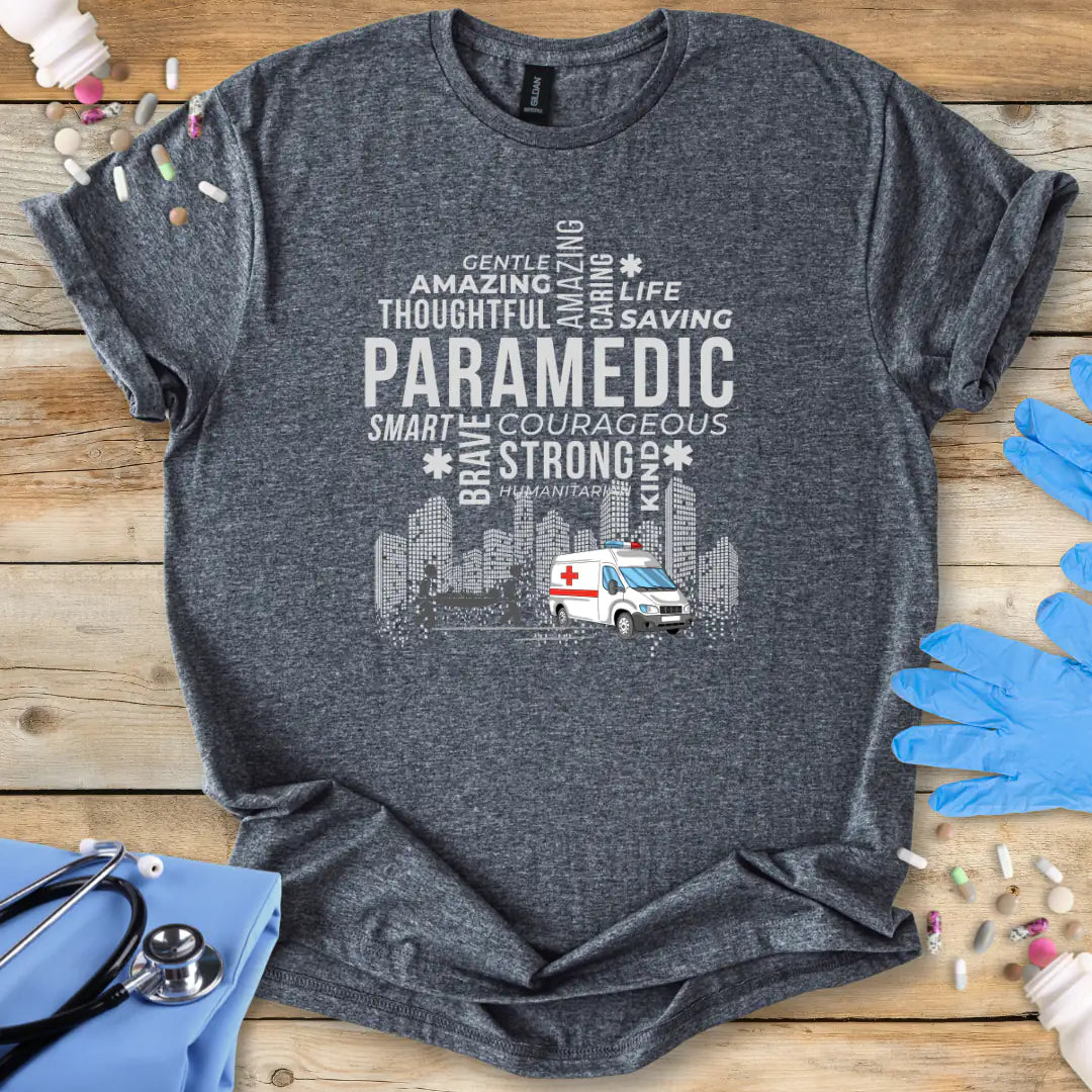 Gray t-shirt with paramedic-themed design on a wooden surface with medical accessories.