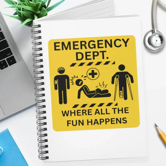 emergency department spiral notebook with 'Emergency Department Where All The Fun Happens' text on a desk.