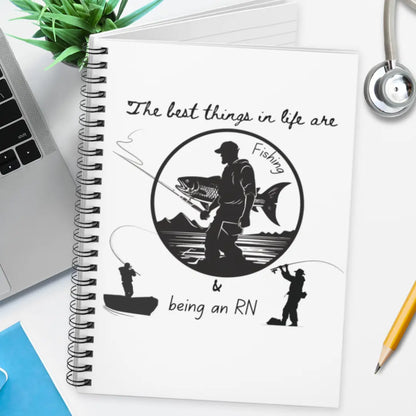 Spiral notebook with a fishing-themed design and 'The Best Things In Life Are Fishing And Being An RN' text on a desk.