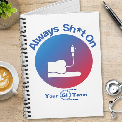 Notebook with a graphic and 'Always Shit On' text on a desk with a cup of coffee and stethoscope.