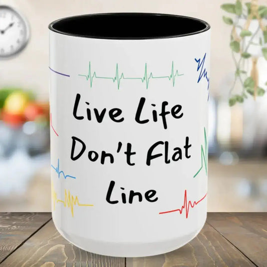 White mug with 'Live Life Don't Flat Line' text and colorful heart rate lines on a wooden surface.