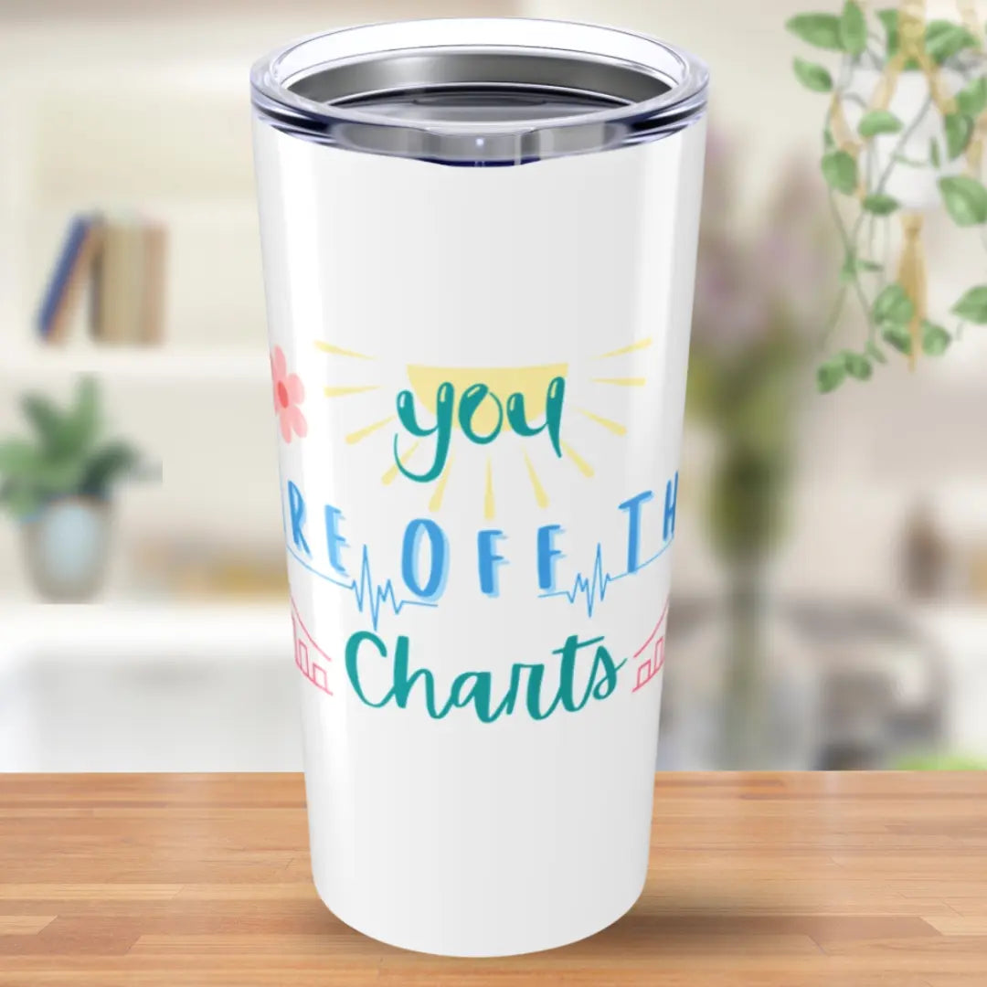 White tumbler with colorful text 'You Are Off The Charts' on a wooden surface