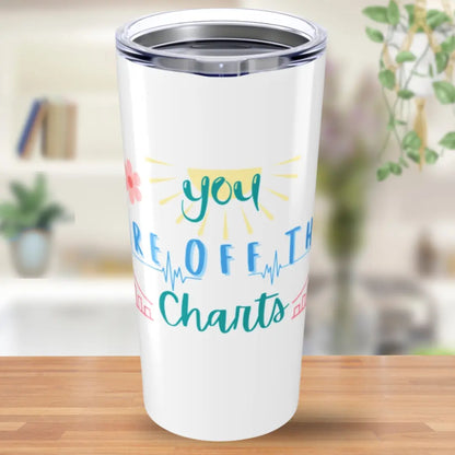 White tumbler with colorful text 'You Are Off The Charts' on a wooden surface
