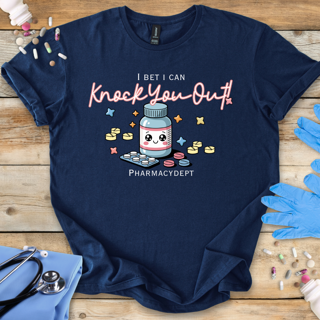 Navy t-shirt with a pharmacy-themed graphic and 'I bet I can knock you out' text on a wooden surface with medical accessories.