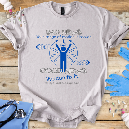 Gray t-shirt with a physical therapy-themed graphic and 'Your range of motion is broken' on a wooden surface with gloves and tools.