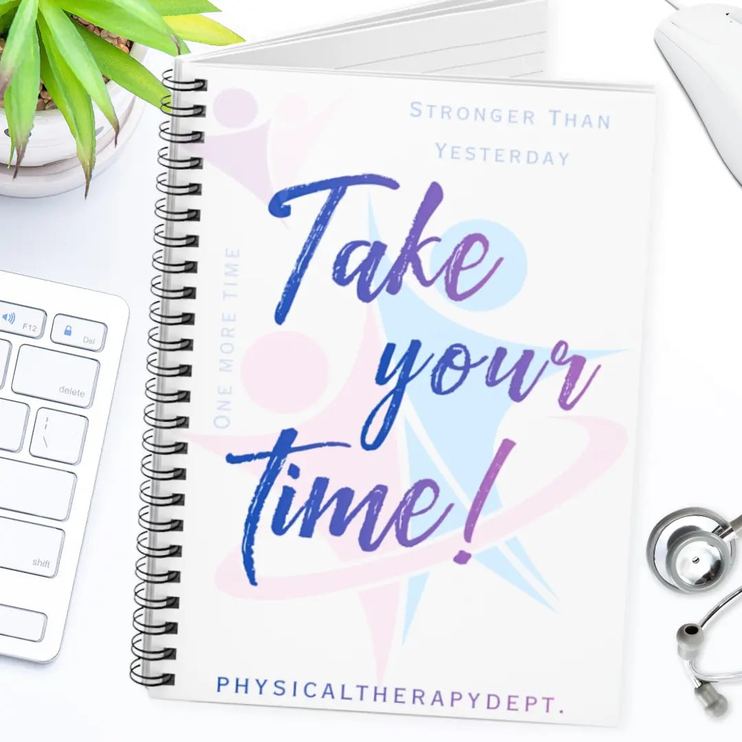 Spiral notebook with 'Take your time!' logo on a desk with a keyboard and plant