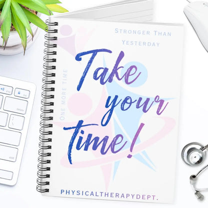Spiral notebook with 'Take your time!' logo on a desk with a keyboard and plant