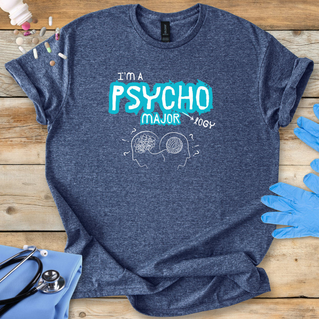 Blue t-shirt with 'I'm a Psycho Major' design on a wooden surface with gloves and stethoscope.