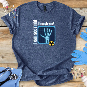 Heather Blue t-shirt with radiology humor graphic and 'I can see right through you' on a wooden surface with gloves and pills.