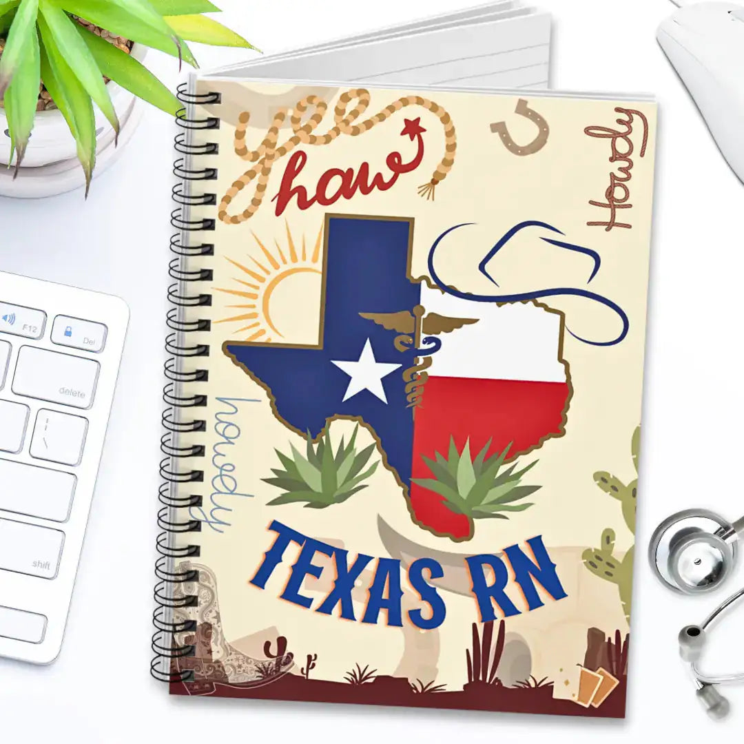 Notebook with Texas RN design on a desk with a keyboard and plant.