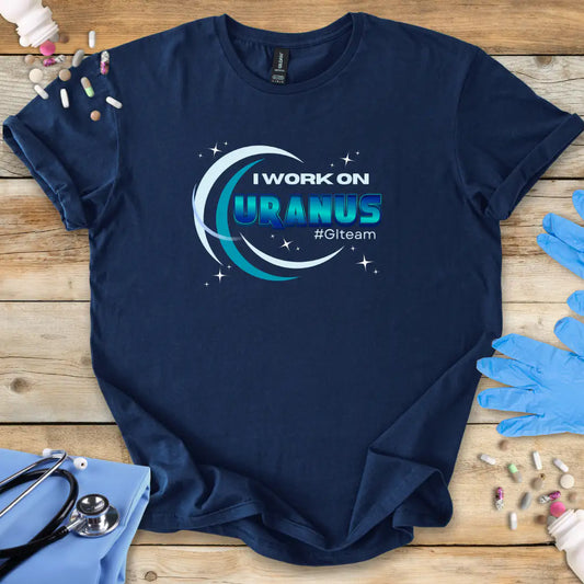 Navy blue t-shirt with 'I Work on Uranus' #GITeam' text graphic on a wooden surface with medical supplies.