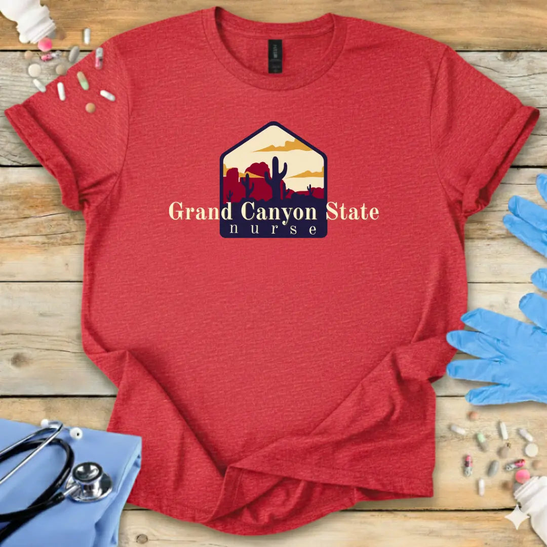 Red med t-shirt with 'Grand Canyon State Nurse' design on a wooden surface with medical supplies.