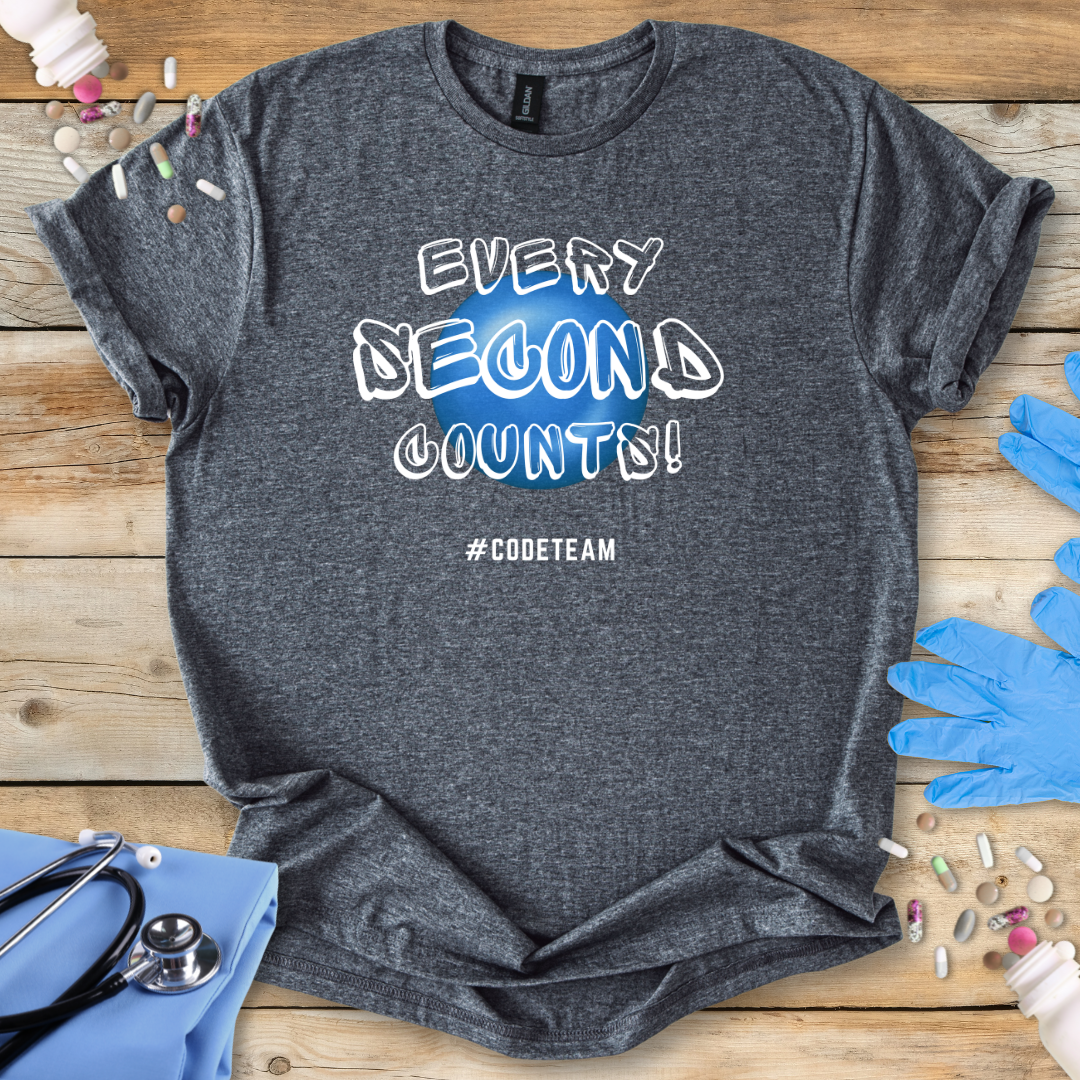 Gray t-shirt with 'Every Second Counts! Code Teams' print on a wooden surface with medical supplies.