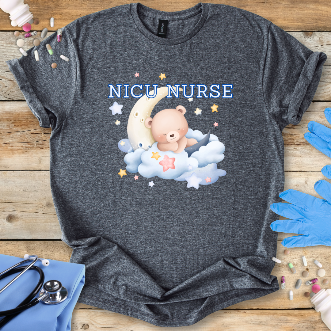 Gray t-shirt with NICU Nurse text featuring a bear and moon on a wooden surface with medical supplies.