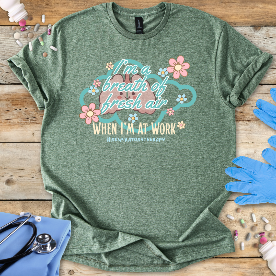 Green t-shirt with a graphic and 'I'm a breath of fresh air text on a wooden surface with gloves and medical items.