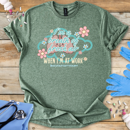 Green t-shirt with a graphic and 'I'm a breath of fresh air text on a wooden surface with gloves and medical items.