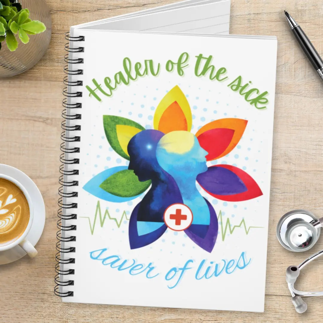Notebook with colorful design and 'Healer Of The Sick Saver Of Lives' text on a wooden surface with a stethoscope.